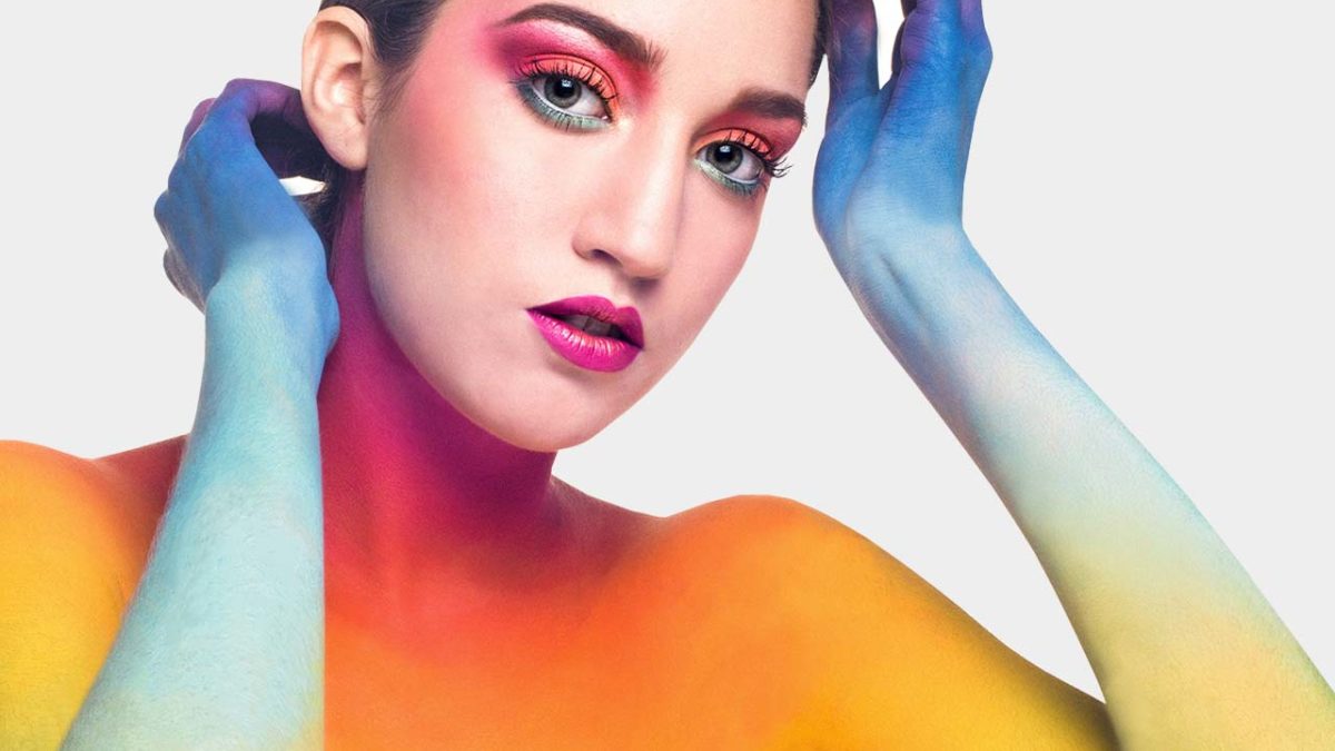Colorful artistic makeup on model's face.